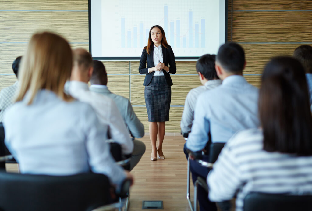 Female teacher or speaker explaining project to managers, Strategie Resilienz stärken