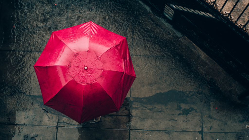 Roter Schirm im Regen, Widerstandskraft, Resilienz, Resilienzfaktor