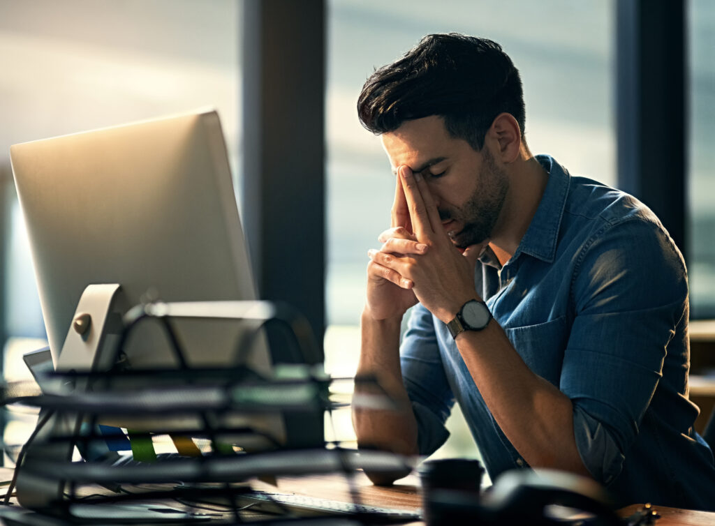 Shot of a young businessman experiencing stress during a late night at work.